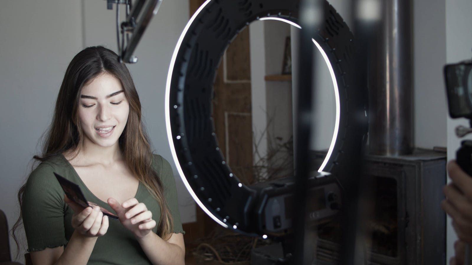 Creadora preparando contenido frente a aro de luz y móvil