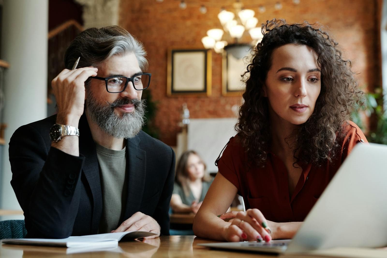 Dos personas revisando en portátil estrategia de trabajo y crecimiento